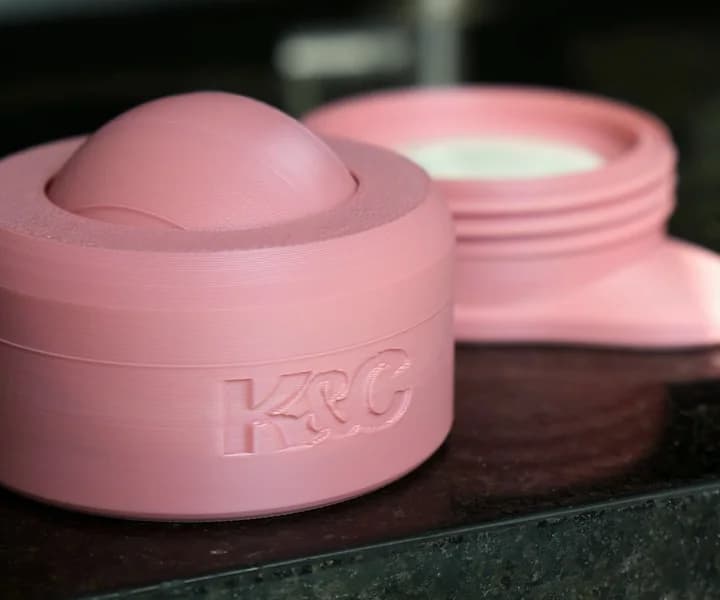 Topo com a bolinha e base do Lume rosa separados sobre a bancada